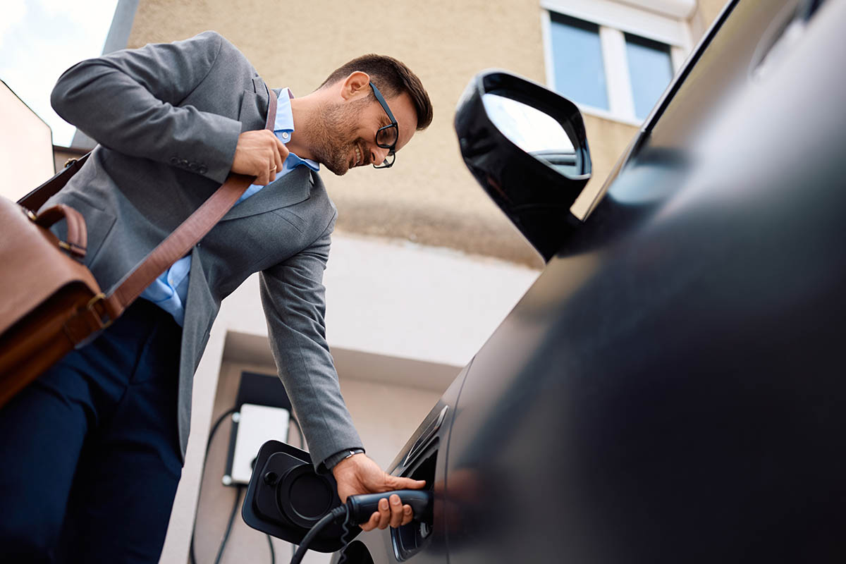 Empresario o autónomo recargando coche híbrido enchufable